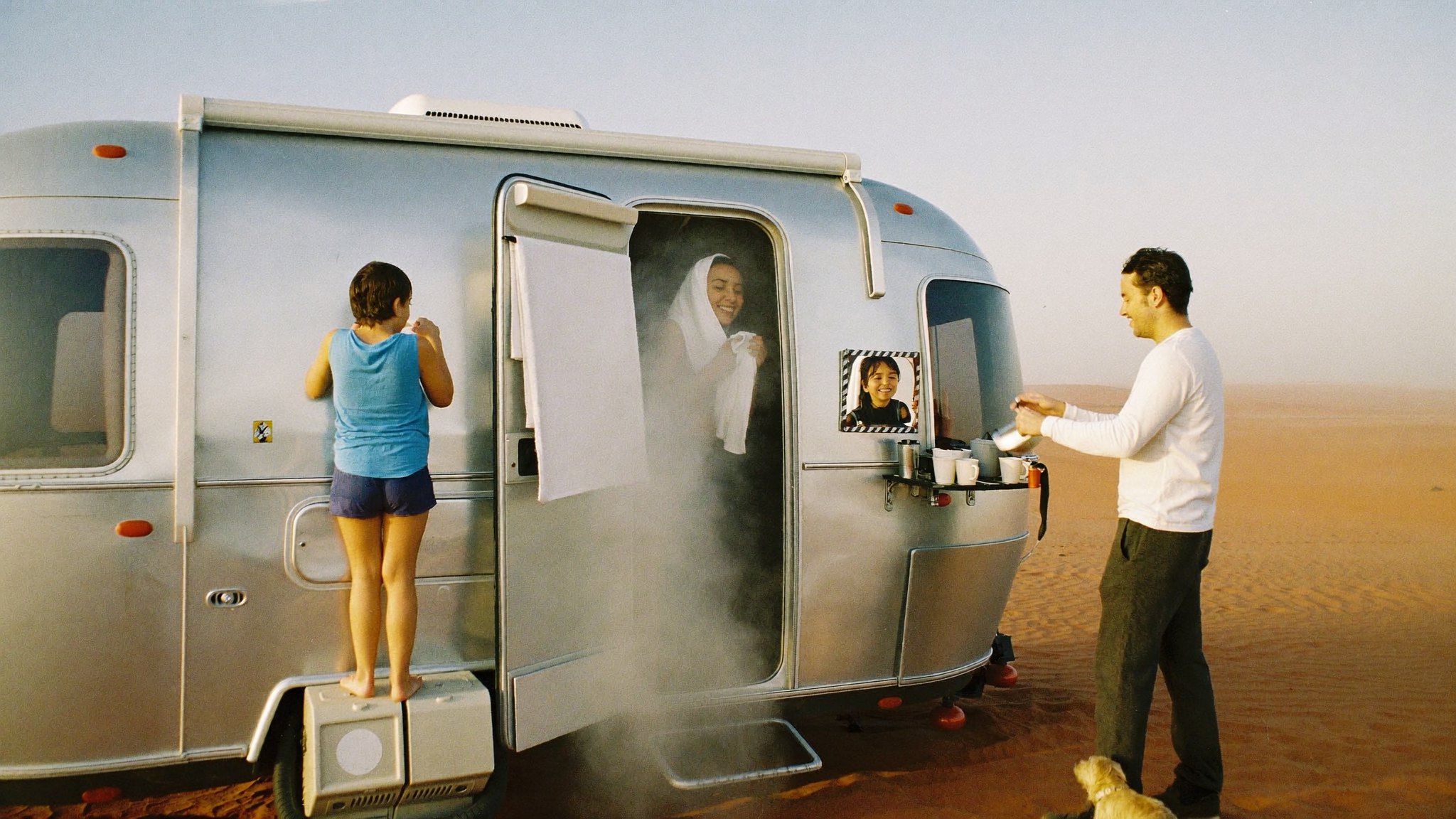 Mum stepping fresh from the trailer's hot shower in the morning desert light