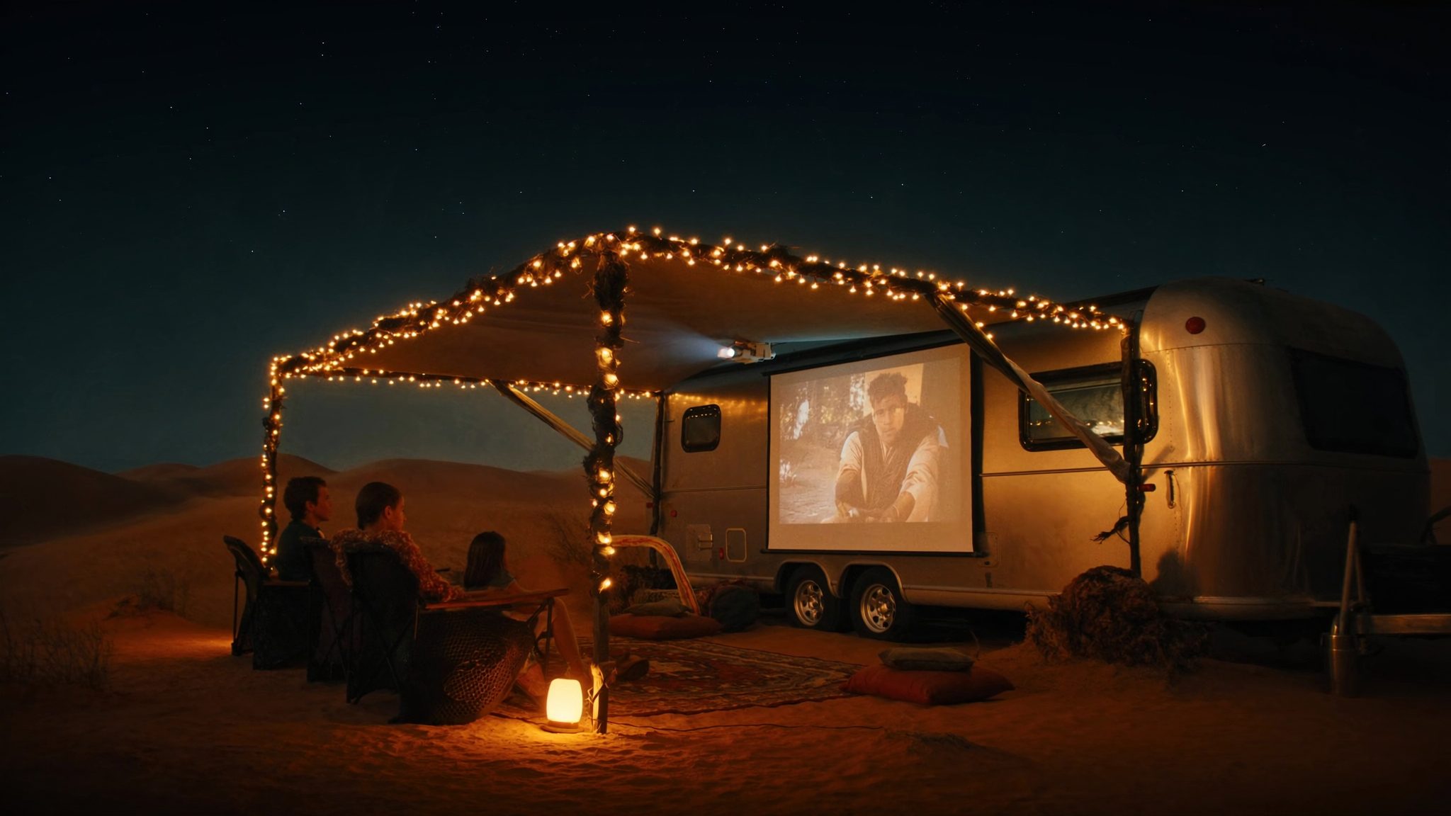 A family at an outdoor cinema beside the trailer